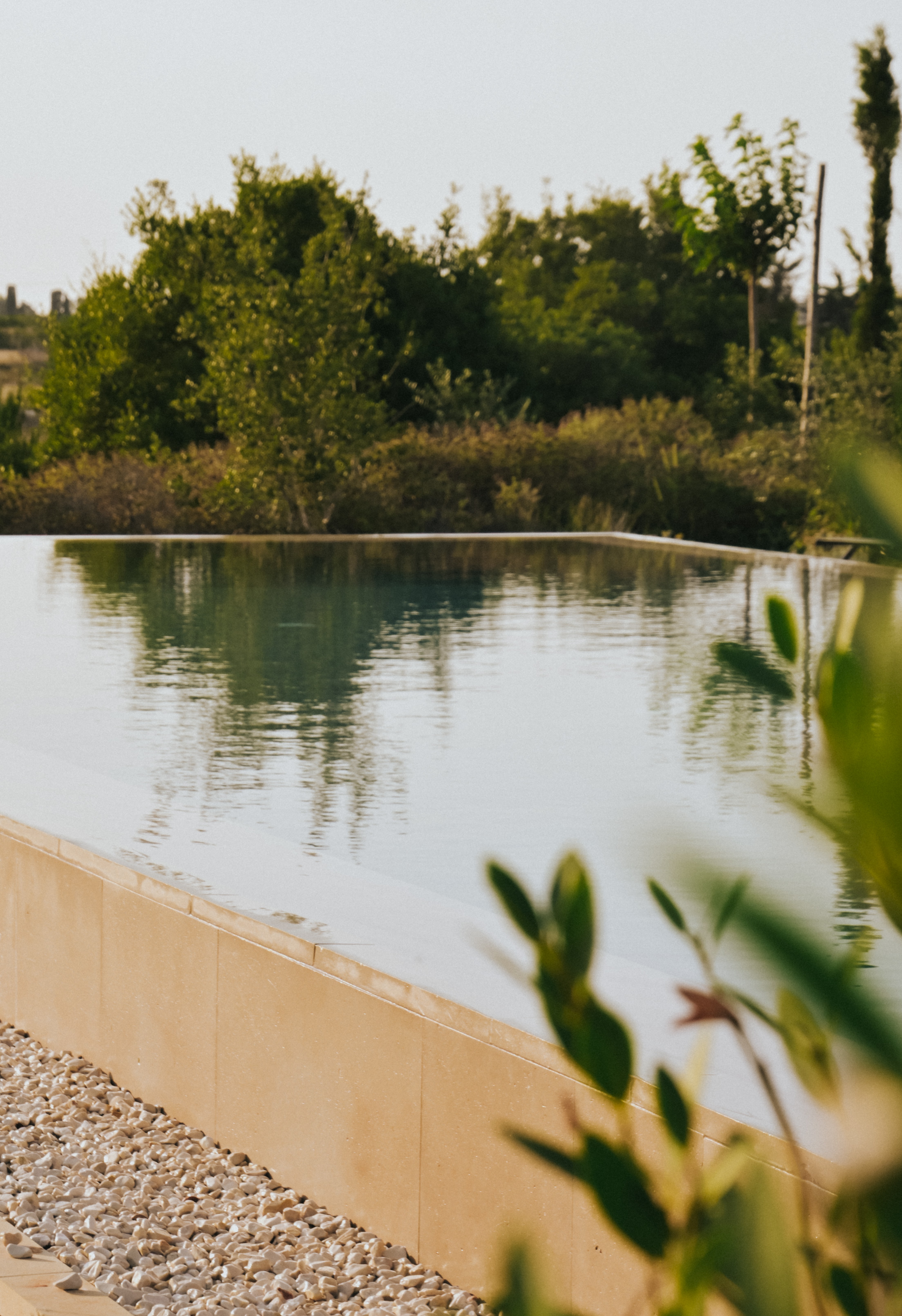 Una piscina al tramonto, con una calda luce dorata che si riflette sull'acqua.